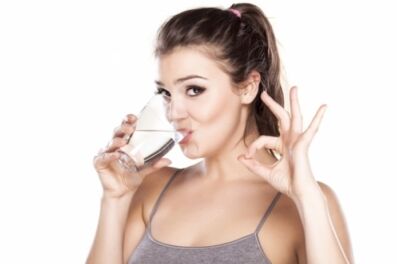 La ragazza beve acqua pulita