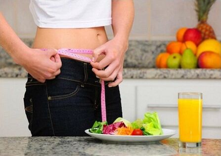 Una ragazza che perde peso mentre segue una dieta misura il suo girovita